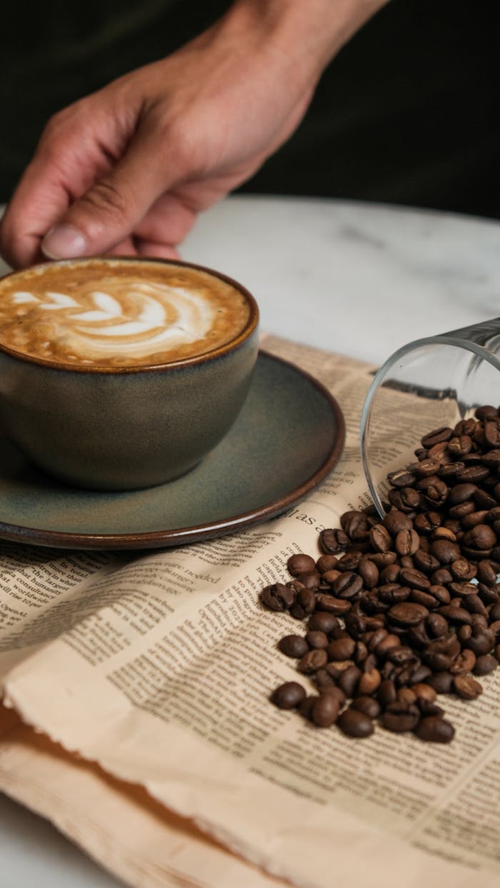 gallery-3 Handcrafted coffee with latte art, surrounded by coffee beans on a rustic table.