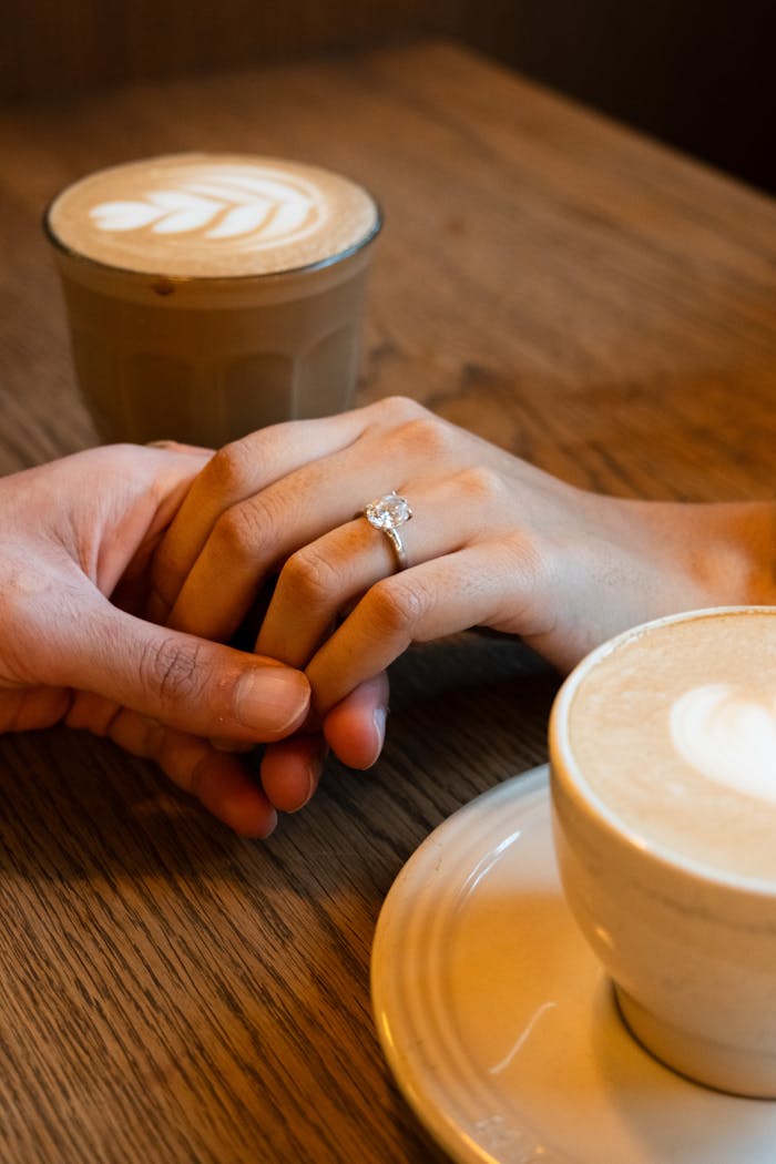about-01 A romantic moment between a couple holding hands over coffee in a Vancouver café.