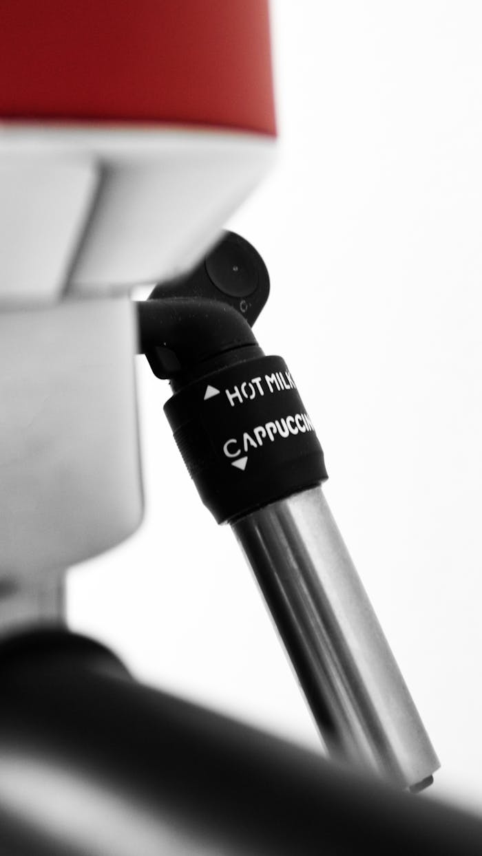 why-choose-us Detailed shot of an espresso machine's steam wand for cappuccino and hot milk preparation.